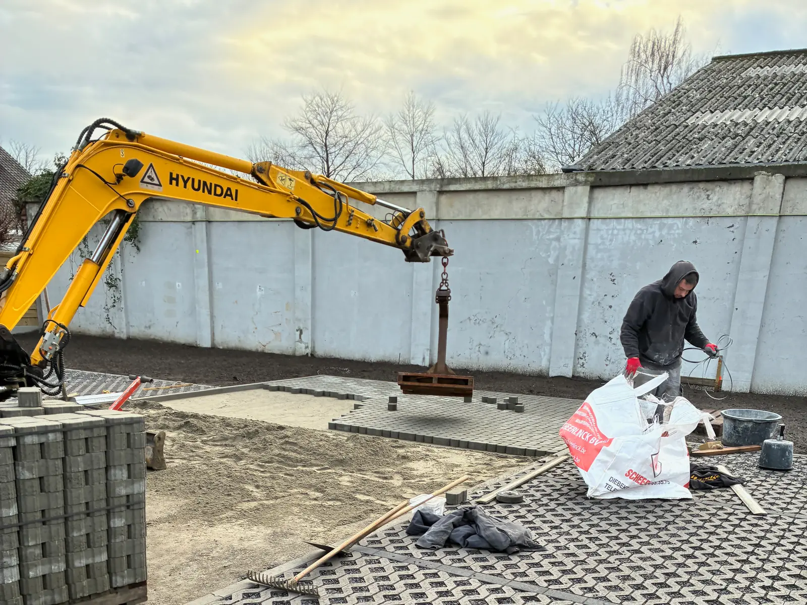 Siebe De Wachter bij het leggen van grasdallen met de kraan en een klemtang